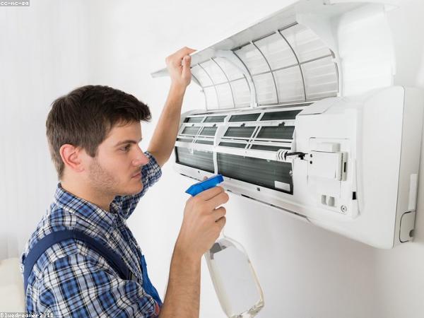 Technician servicing a split air conditioner