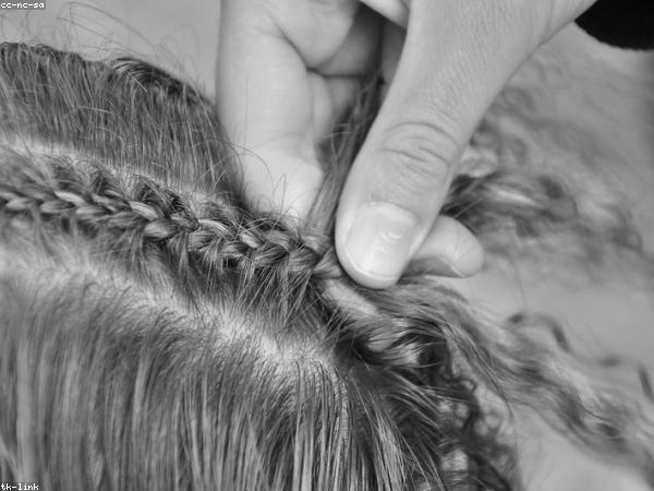 Stylist braiding a client's hair in a Lekki salon