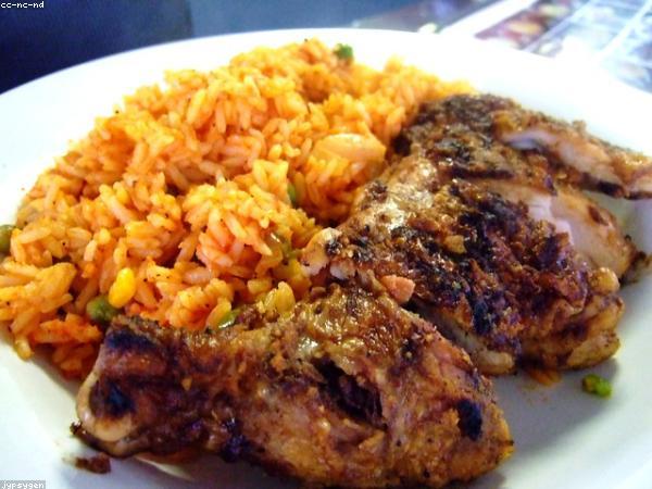 Plates of jollof rice and grilled fish