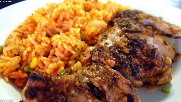 Plates of jollof rice and grilled fish