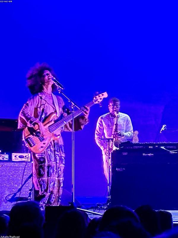 A bassist and a saxophonist on a stage lit blue